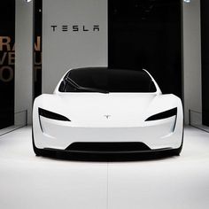 a white car is parked in front of some black and white wallpaper with the word tesla on it