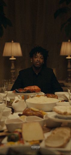 a man sitting at a table covered in plates and bowls with food all over it