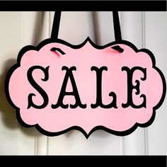 a pink sale sign hanging from the side of a door