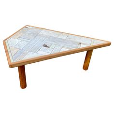 a wooden table with a marble top and two legs on each side, against a white background