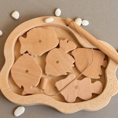 a wooden bowl filled with fish and white beans on top of a gray tablecloth