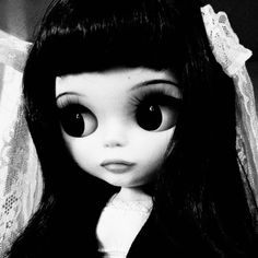 a black and white photo of a doll with big eyes