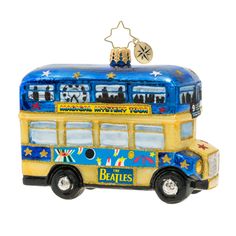 a blue and yellow bus ornament with stars on it's roof, sitting in front of a white background