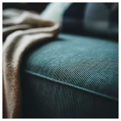 a close up view of a couch with a blanket on it's back end