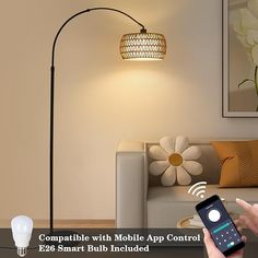 a person holding a smart phone in front of a lamp with the text compatible with mobile app control