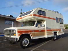 an rv parked in a parking lot next to a building