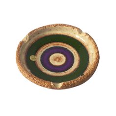 a purple and green bowl sitting on top of a white table