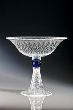 a glass bowl sitting on top of a table next to a blue object in the middle