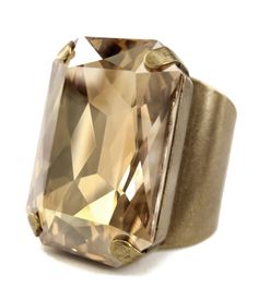 "Effervescent and highly-refined... A sophisticated, over-sized crystal statement ring for men and women. This exquisitely-faceted Swarovski crystal is warm-hued and sparkling, like a glass of the finest champagne. The super-comfortable, wide cuff-style band adjusts to fit approx. sizes 6.5 to 10+ -- unisex sizing for men and women! The band is antiqued brass plate over base metal. - Large rectangular Swarovski crystal: 18 x 24mm (3/4\" x 1\") - Super-comfortable antiqued brass plated wide cuff Golden Champagne, Brass Plate, Gold Champagne, Ring For Men, Wide Cuff, Crystal Ring, Large Crystals, Faceted Crystal, Sparkling Crystal