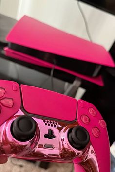 a pink video game controller sitting on top of a table