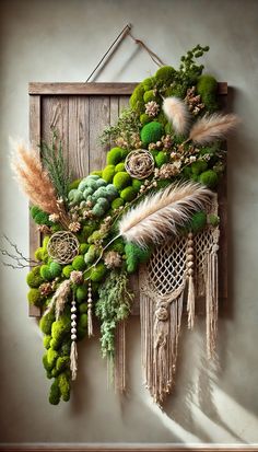 a wall hanging made out of plants and feathers