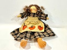 the doll is wearing a dress with pumpkins on it's chest and legs