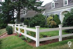 a white picket fence in front of a large house