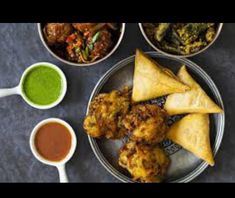 three bowls filled with food next to dipping sauces and pita chips on a plate