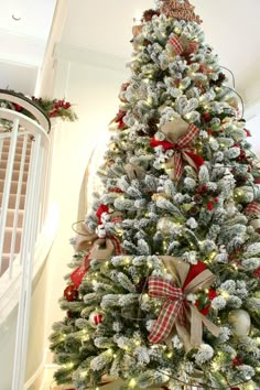 a decorated christmas tree with red and white bows