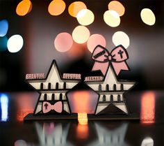 two wooden stars with bows on them are sitting on a table in front of some blurry lights