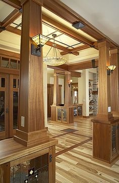 the inside of a building with wooden floors and columns on either side of the room