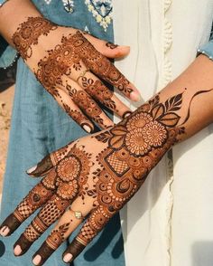 two hands with henna tattoos on them