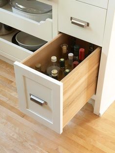 an open drawer in the middle of a kitchen with spices and condiments inside