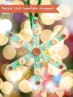 a snowflake ornament made out of buttons on a christmas tree with the words, popsicle stick snowflake ornaments