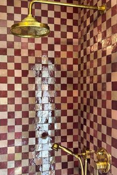 a shower head and faucet in a bathroom with checkered tile on the walls