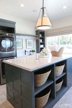 a kitchen island with baskets on it and a washer dryer in the background