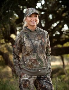 a woman in camo clothing is smiling for the camera