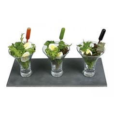 three glass bowls filled with different types of food on top of a metal platter