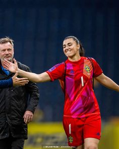 two soccer players are shaking hands on the field