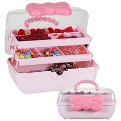 a pink and white box with two compartments filled with candy, candies and other items