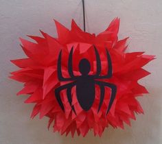 a red and black spiderman pinata hanging from a wall