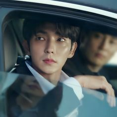 two young men sitting in the back seat of a car