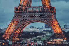 the eiffel tower lit up at night with lights on it's sides