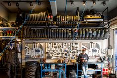 a man standing in front of a workbench with lots of tires on it