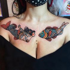 two colorful fish tattoos on the upper half of a woman's chest and shoulder