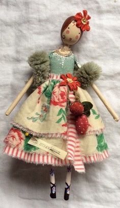 the doll is wearing a dress with flowers and berries on it's back legs