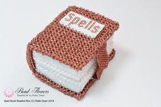 there is a small knitted book that has the words spelled on it and sits in front of a white background