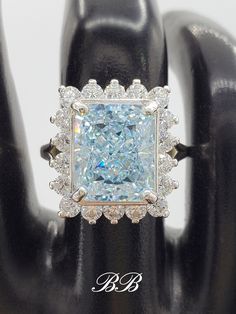 an engagement ring with a fancy blue diamond surrounded by white and clear diamonds on top