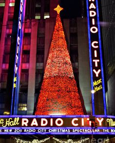 the radio city christmas tree is lit up at night