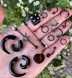 a person holding several pairs of fake black and white rings