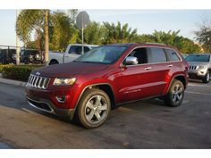 a red jeep is parked in a parking lot