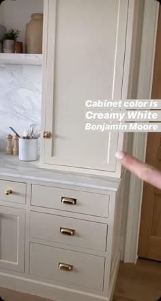 the cabinets in this kitchen are white and have gold pulls on them to pull open