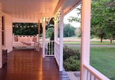 the porch is covered with white furniture and string lights on both sides of the porch