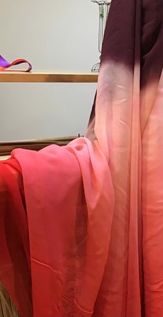 an orange and pink sari draped over a bed