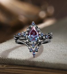 a fancy ring with blue and white stones on it sitting on top of a book