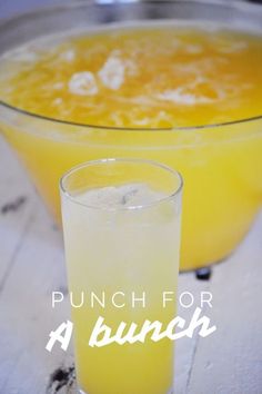 a glass filled with liquid next to a bowl full of orange juice