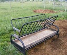 a metal bench sitting in the middle of a field