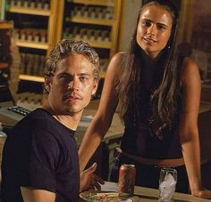 a man and woman sitting at a table with food