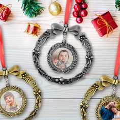 two christmas ornament hanging on a wooden table with presents and ornaments around it