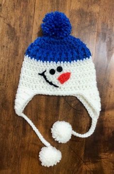 a crocheted snowman hat on top of a wooden floor